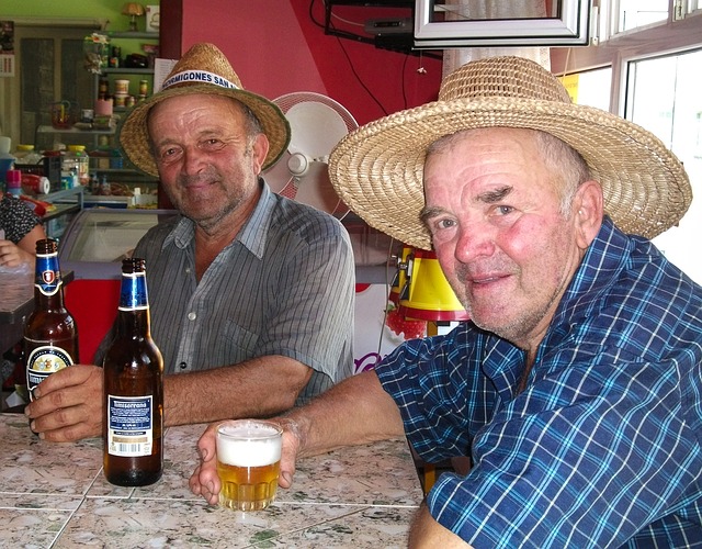 dva starší pánové sedící a popíjející pivo